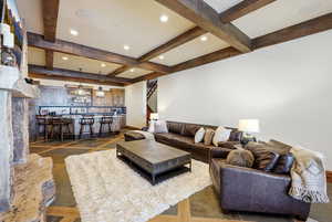 Living room featuring stairway, inlaid floor details, recessed lighting, and beamed ceiling