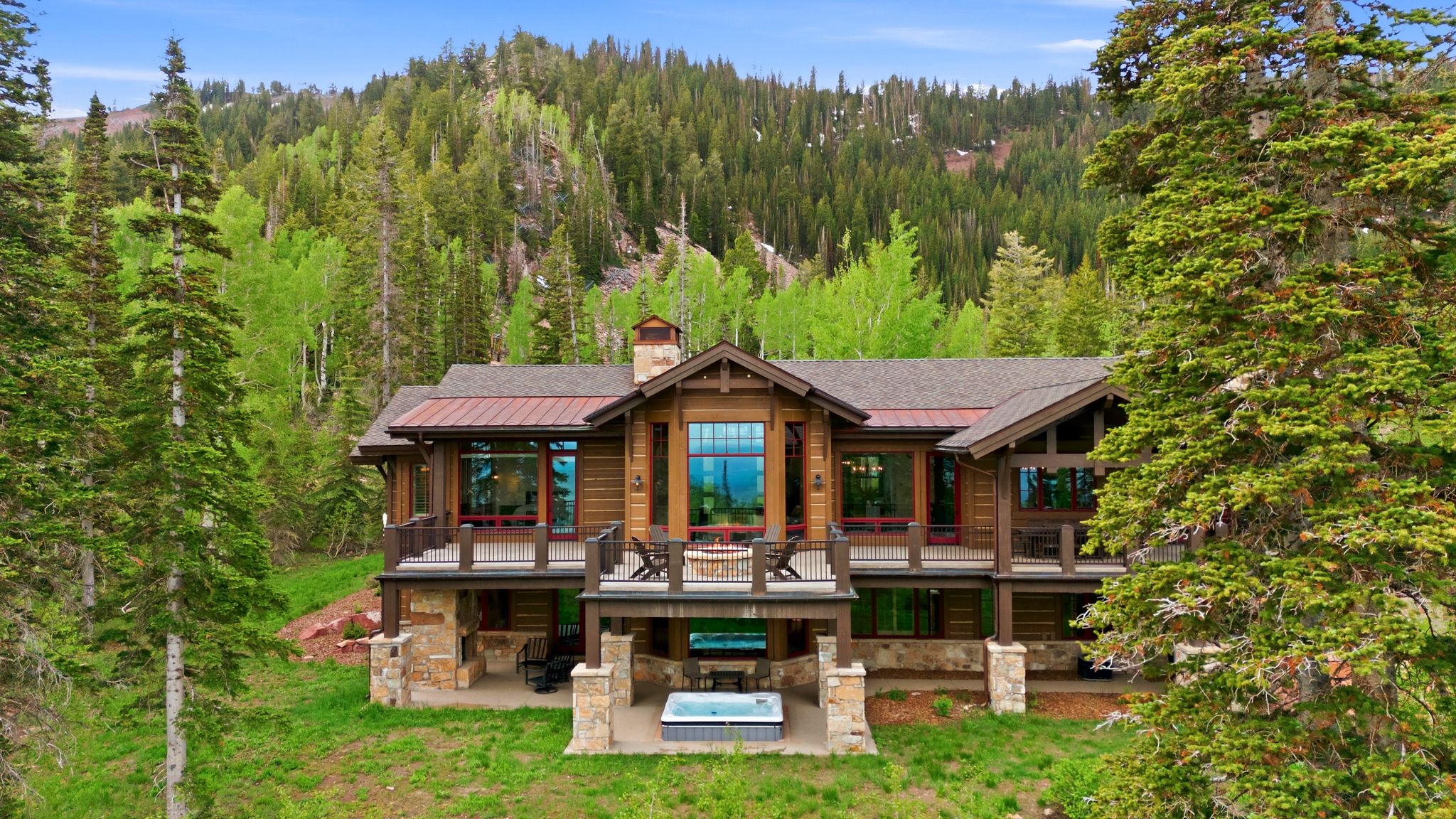 Expansive mountain residence featuring a multi-level design, wood siding, and stone accents