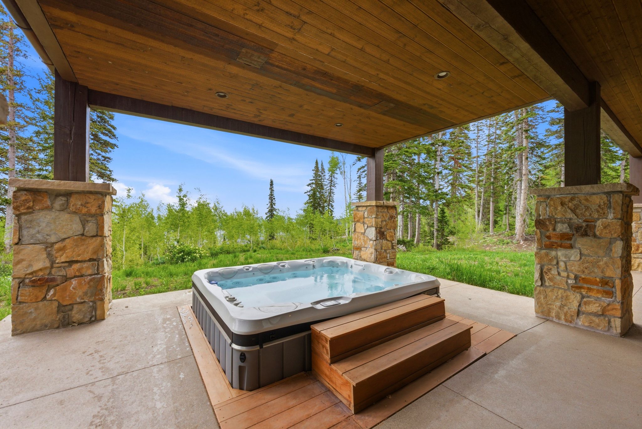 Covered patio featuring an integrated hot tub with wood-finish steps
