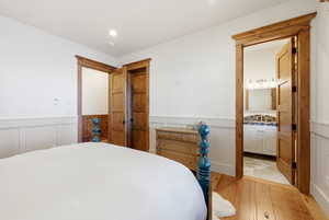 Bedroom featuring a wainscoted wall and hardwood / wood-style floors
