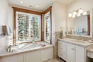 Full bath featuring a bath, vanity, and recessed lighting