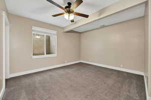 Empty room featuring carpet flooring and a ceiling fan