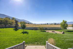 Fenced backyard with a view of rural / pastoral area and a mountain view