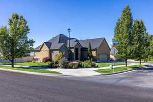 French country style house featuring stone siding, a front yard, and stucco siding