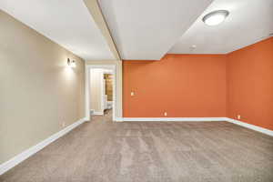 Empty room with light carpet and baseboards