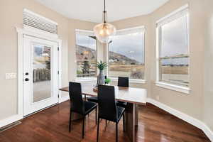 Dining space featuring dark wood-style floors and a mountain view