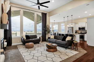 Living area with a fireplace, a ceiling fan, recessed lighting, and dark wood-type flooring