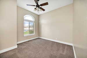 Carpeted empty room with baseboards and a ceiling fan