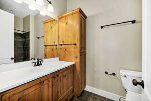 Full bath with vanity, a shower with shower curtain, and dark tile patterned flooring