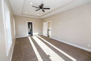 Unfurnished bedroom featuring a raised ceiling, carpet floors, ceiling fan, and recessed lighting