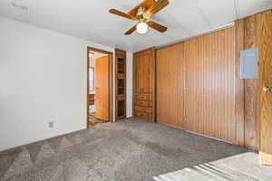 Unfurnished bedroom with carpet, electric panel, and ceiling fan