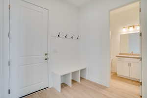 Mudroom with light wood-style floors and a sink