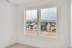 Carpeted spare room featuring baseboards and a mountain view