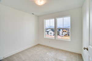 Spare room with light carpet and baseboards