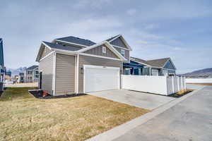 View of front of property featuring board and batten siding, concrete driveway, a mountain view, and a shingled roof