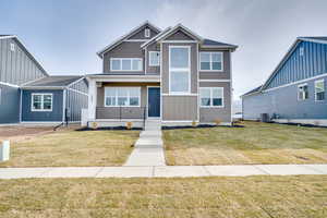 View of front of property featuring a front yard and covered porch