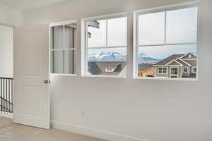 Empty room featuring a mountain view and baseboards