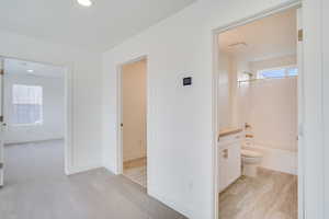 Corridor with light carpet and recessed lighting