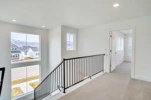 Hallway with carpet flooring, recessed lighting, a mountain view, and an upstairs landing
