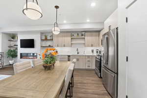 Kitchen featuring modern cabinets, light brown cabinets, dark wood-style flooring, and stainless steel appliances