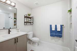 Bathroom featuring vanity, light tile patterned flooring, and a shower