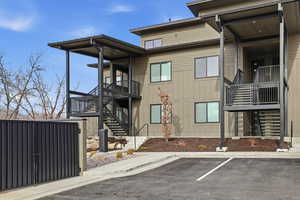 View of building exterior with stairs and uncovered parking