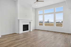 Unfurnished living room featuring a fireplace, light wood finished floors, a ceiling fan, and recessed lighting