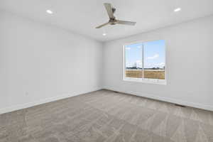 Empty room featuring light colored carpet, a ceiling fan, and recessed lighting