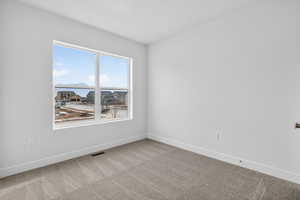Empty room featuring baseboards and carpet