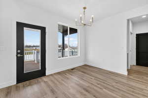 Unfurnished dining area with light wood-style flooring and a chandelier