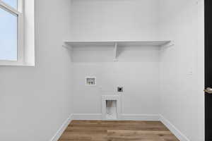 Laundry area with hookup for an electric dryer, light wood finished floors, and washer hookup
