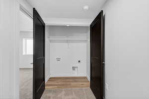 Laundry area with hookup for an electric dryer, light colored carpet, and hookup for a washing machine