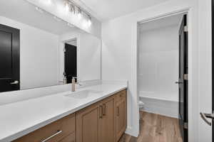 Bathroom featuring vanity, light wood finished floors, and shower / washtub combination
