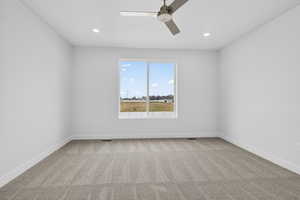 Empty room with light carpet, ceiling fan, and recessed lighting