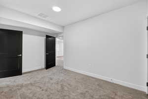Unfurnished bedroom featuring light carpet and baseboards