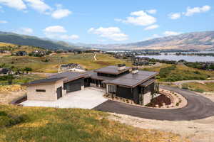 View of front facade featuring driveway, a mountain view, a garage, and a metal roof