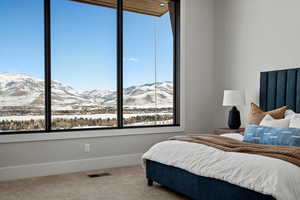 Carpeted bedroom with a mountain view and baseboards