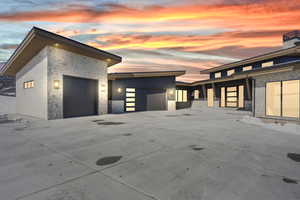 View of front of home with stone siding, a garage, and driveway