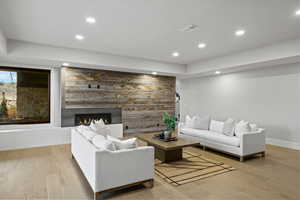 Living area with light wood finished floors, a fireplace, recessed lighting, and an accent wall