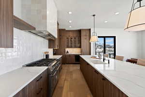 Kitchen with double oven range, light stone countertops, recessed lighting, modern cabinets, and backsplash