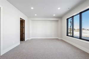 Empty room with recessed lighting and light carpet