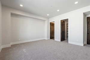 Unfurnished bedroom with light carpet and recessed lighting