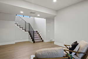 Living area with recessed lighting, light wood-type flooring, and stairs