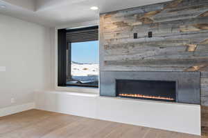 Detailed view of wood finished floors, recessed lighting, and a fireplace
