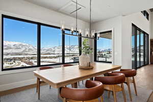 Dining area with a mountain view, light wood finished floors, and a chandelier