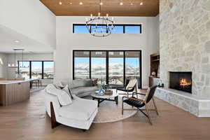 Living room featuring a chandelier, recessed lighting, hardwood / wood-style flooring, wooden ceiling, and a mountain view
