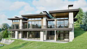 Rear view of house with a chimney, a lawn, and a patio