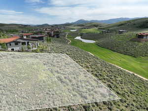 Aerial view of property's location with property parcel outlined and a water and mountain view