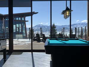 Recreation room with a mountain view, billiards, healthy amount of natural light, and a wall of windows