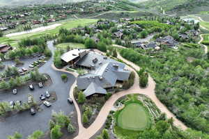 Aerial view of property and surrounding area with a golf course and nearby suburban area